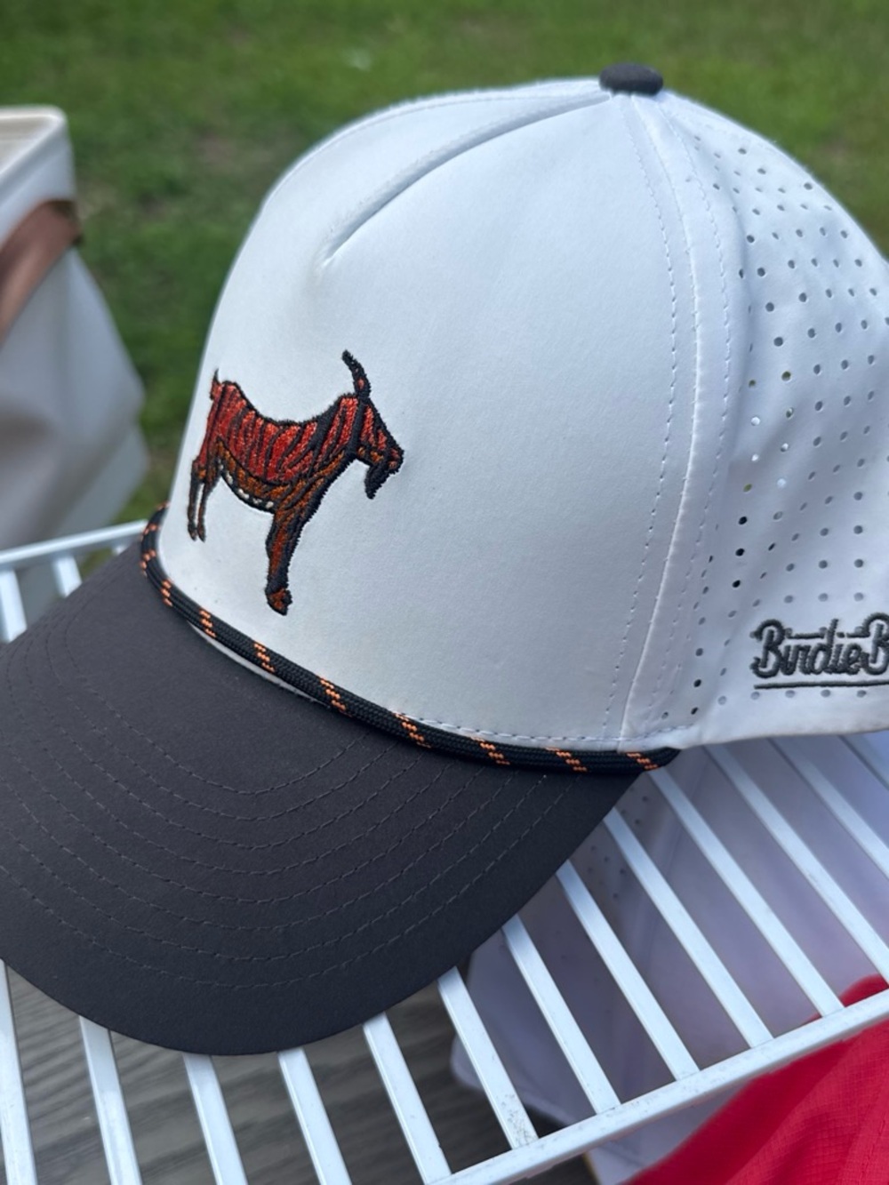 White and Charcoal Golf Cap with Orange “tiger” goat logo. Birdiebros brand